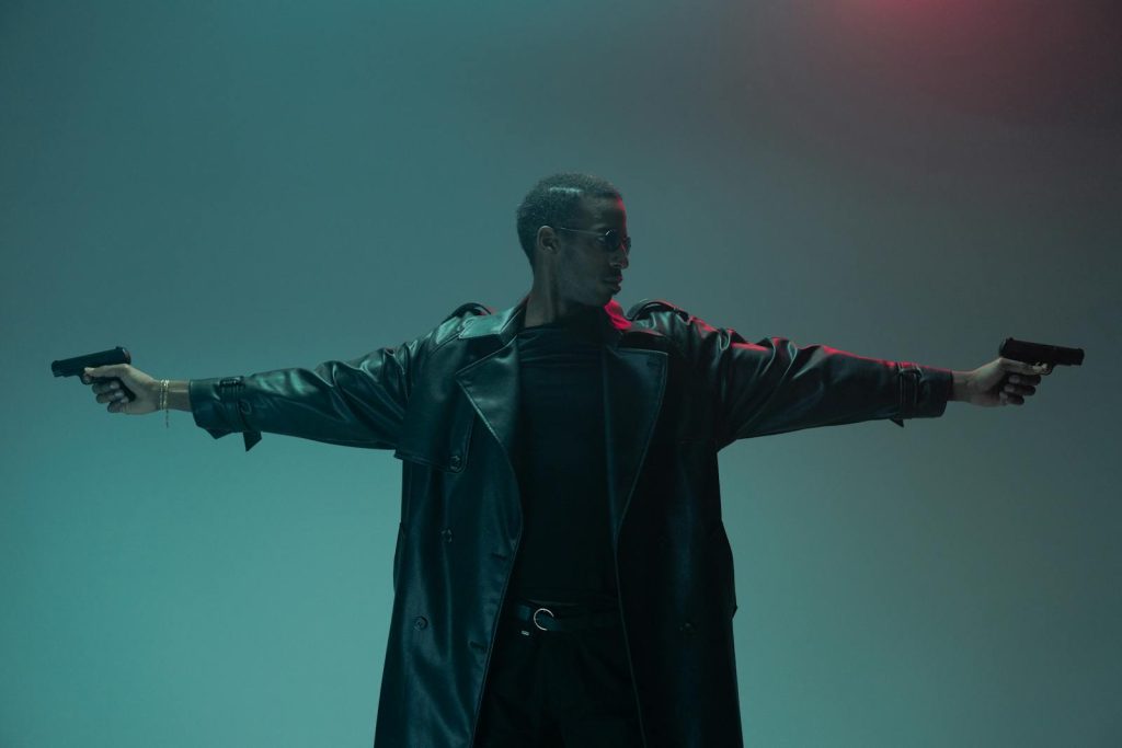Man in a Leather Coat Holding Guns