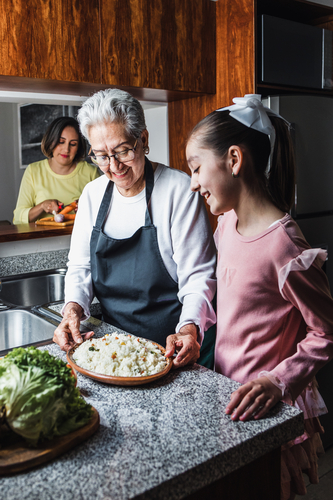 Hispanic women family grandmother, mother and granddaughter cooking at home at kitchen in Mexico Latin America