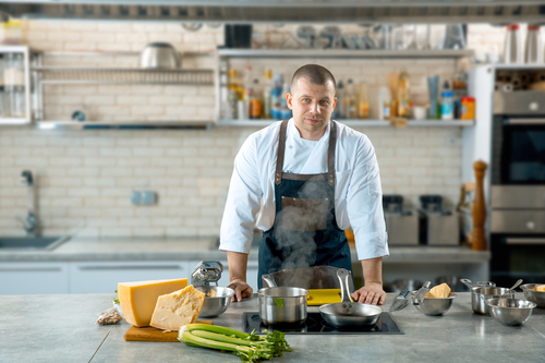 Handsome male chef in the kitchen interior