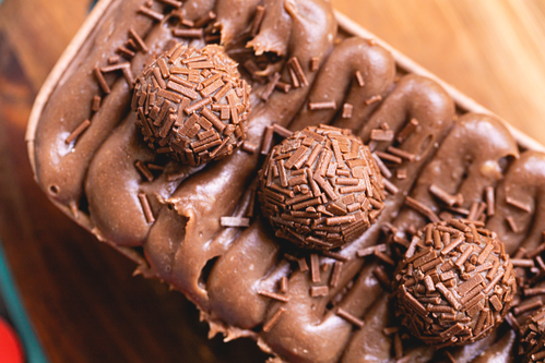 Chocolate cake with chocolate frosting and brigadiers to decorate. The name of this dessert in Brazil in Brazilian Portuguese is: caseirinho de brigadeiro.