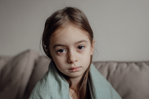 Stop war. Pray for Ukraine. we stand with Ukraine. Ukrainian frightened child under a blanket. The girl is afraid of the sounds of air raids and explosions. Poor child feeling sorrow and sadness, bad luck and grief problems. 