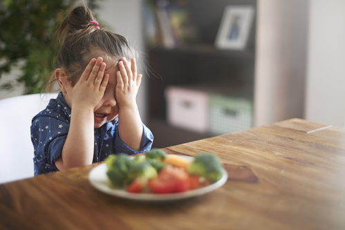 Baby girl and vegetables on the kitchen