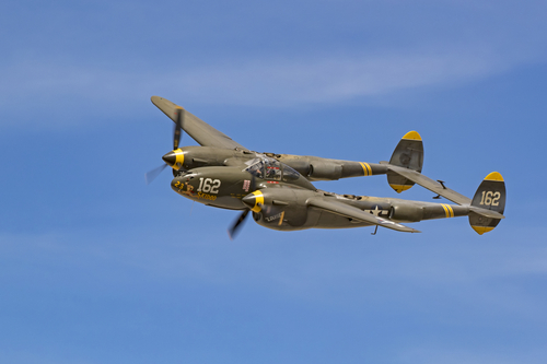 Airplane P-38 Lightning WWII fighter aircraft flying at the air show