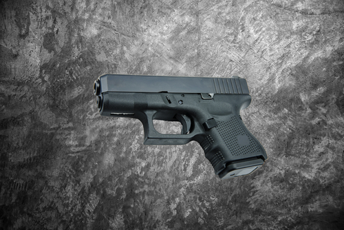 automatic 9mm. handgun pistol on cement wall background.