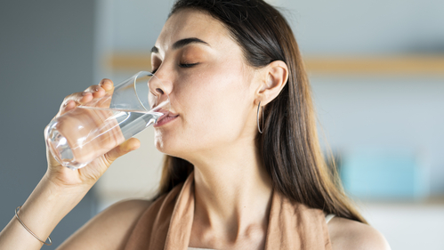 Young woman drinks a glass of water