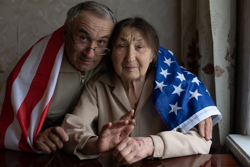very elderly man and woman with america flag