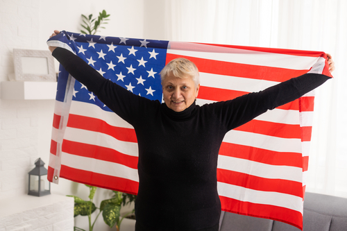 Elderly woman holding an American flag.