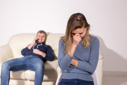 domestic violence, abuse and family concept - crying woman and her husband on the background