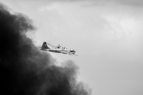 Oshkosh, WI - 28 July 2018:  A B-29 Superfortress bomber flying away from smoke caused by a  bomb it dropped