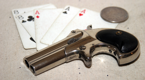Genuine Antique 1887 Double Derringer Pocket Pistol. Isolated on white with room for your text or information. Circa 1889, Model 95, Type II Model 3 Double Derringer on card table with aces and eights aka a Dead Mans Hand. Dead Mans Hand. 