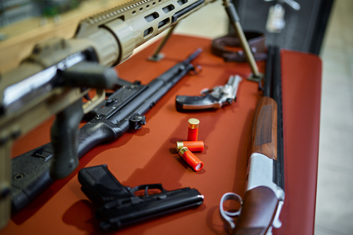Rifles and pistols on counter in gun store closeup, nobody. Weapon shop interior on background, ammunition assortment, firearms choice, shooting hobby and lifestyle, self protection and security
