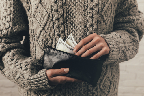 woman holding wallet with dollar banknotes