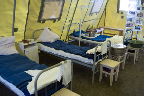 a tent camp from the inside, a military hospital wartime reenactment. beds and shelves for the wounded