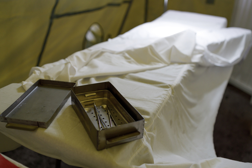 a metal container for storing surgical instruments on a bed in a military hospital. surgical table and instruments