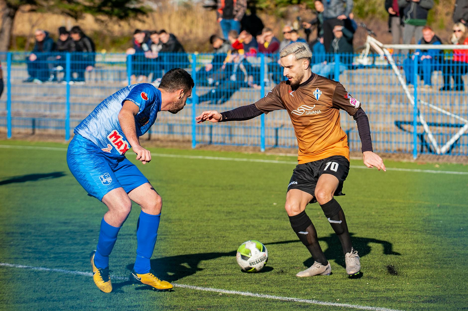 photo of man playing soccer during daytime