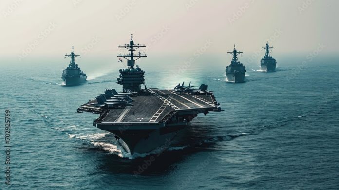 Aerial view. The aircraft carrier accompanied by a squad ships. Photo with space for text.