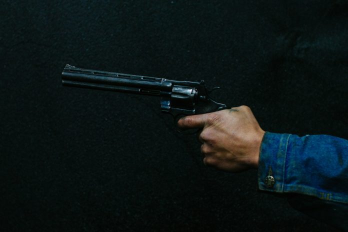 person holding revolver